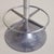 A mid-century French bar stool from the 1960s, its form anchored by a cast aluminum base that flares into a weighted,...