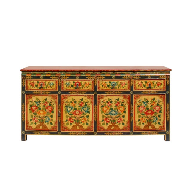 This is a credenza size cabinet with a colorful Tibetan style flower graphic at the front as a decorative accent. The main...