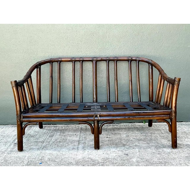 This vintage McGuire bent rattan loveseat exemplifies the brand's signature casual sophistication, its gently arched frame...