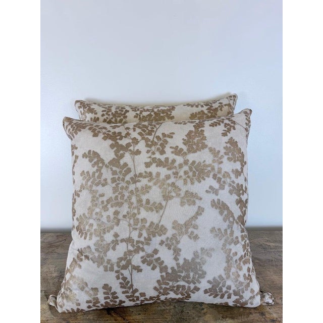 A refined pair of custom square pillows rendered in a luminous linen. The face features an elegant botanical study of...
