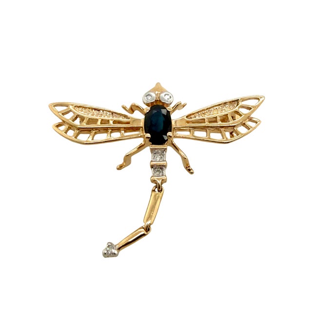 This elegant vintage dragonfly brooch is crafted in 14K yellow gold. The body of the dragonfly tail is a prong set...