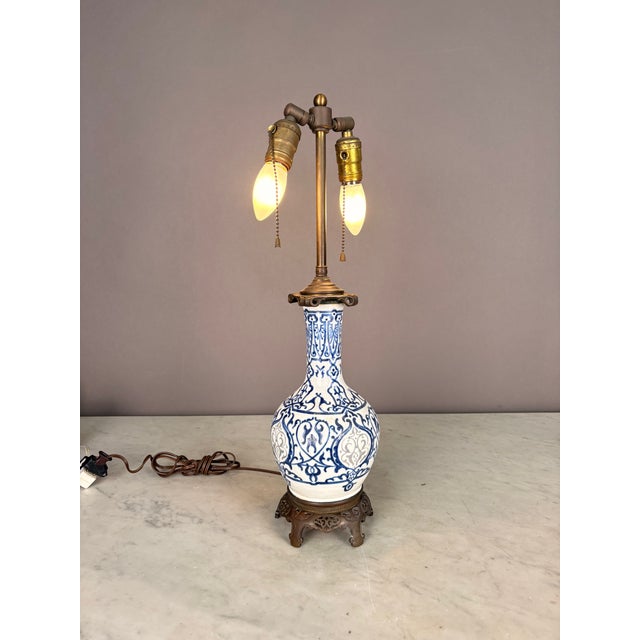 Antique blue and white pattern porcelain lamp with ornate design brass base Two brass Edison sockets in working condition...