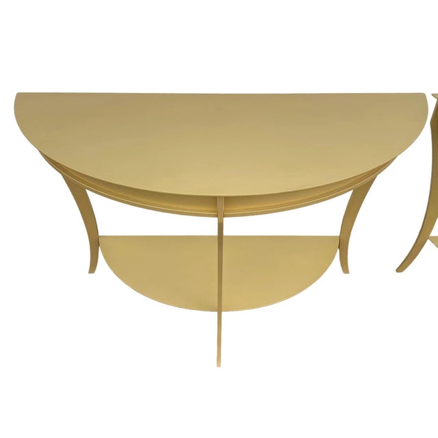 Matching pair of vintage demilune console tables featuring heavy steel construction, graceful curved legs and lower half-...