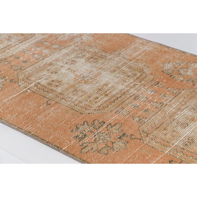 This is a vintage Turkish Oushak rug from the Mid 20th Century. The piece was hand-knotted.