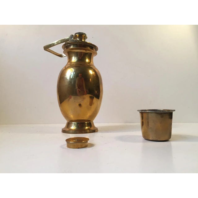 This is a vintage solid brass thermos with a screw-in lid, swivel handle, and a fitted exterior cup. It will work as a...