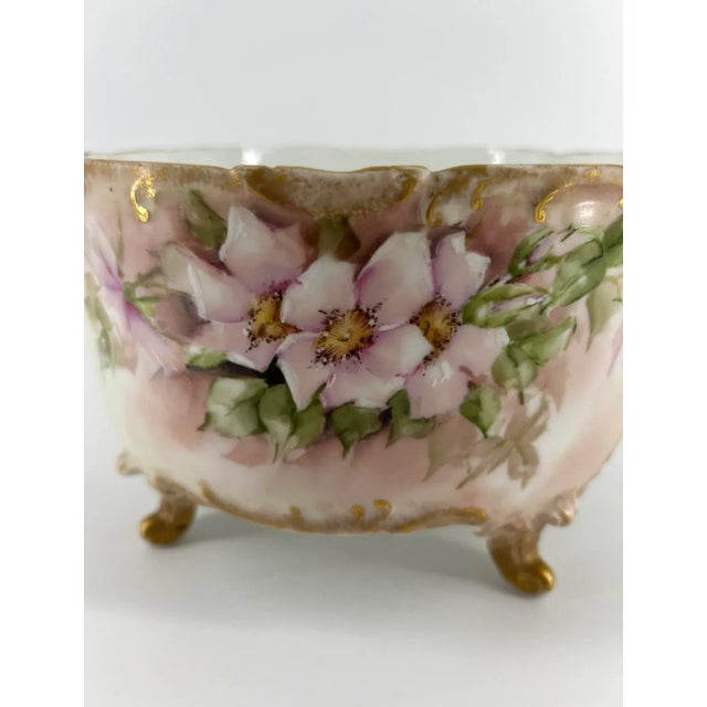 D&Co, Limoges, France hand-painted porcelain bowl, featuring apple blossoms with leaves in pale pink and green tones....