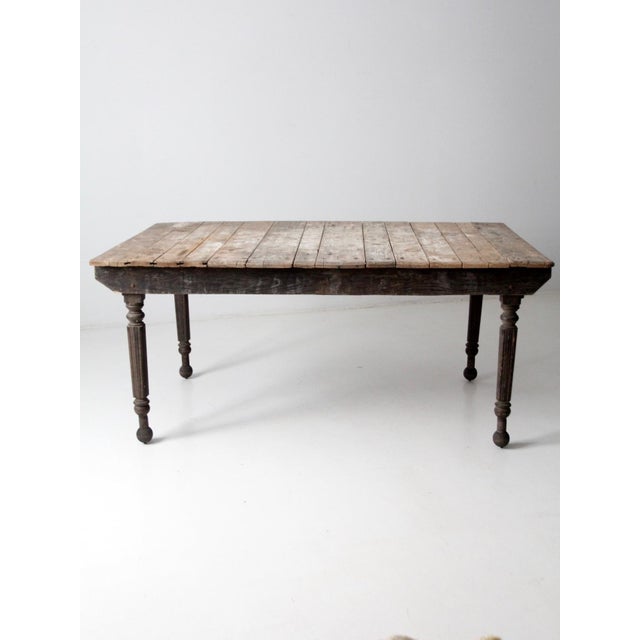 This antique farmhouse harvest table exudes rustic charm and timeless appeal. The wide, rustic plank top is complemented...