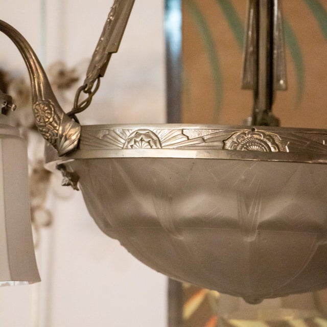 A glass piece with a design consisting of a central bowl and three arms extending from it. Both the bowl and the shades on...