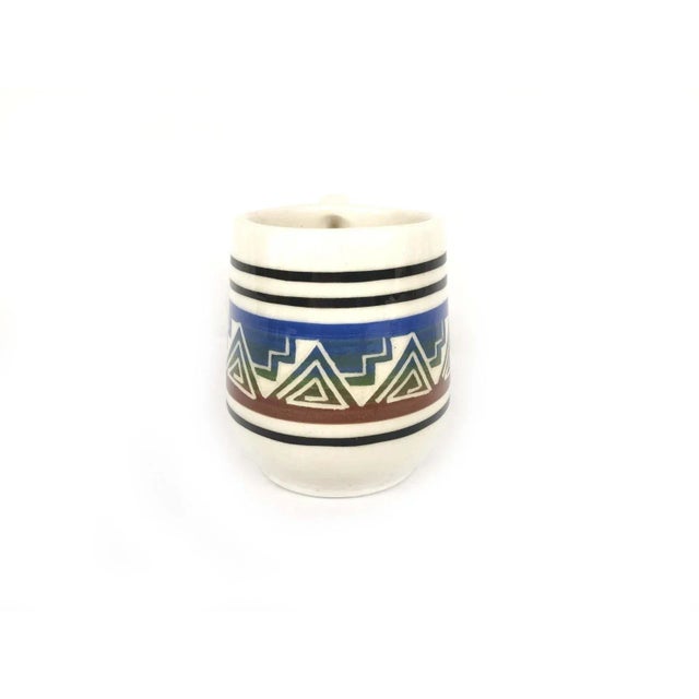 In the photos you will see quite a bit of dark and light reflections due to the glaze This Navajo signed carved mug is a...