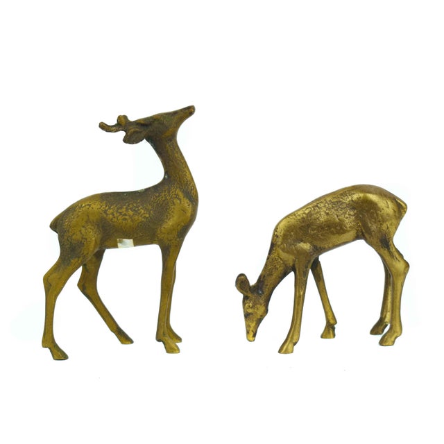 This charming pair of vintage brass figurines captures a serene woodland scene, featuring one stag alert with its head...