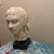 An expressive, hand-modeled plaster bust depicting a woman with a serene, introspective expression. This figurative work...
