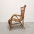 Vintage 1970s armchair crafted from natural rattan. The sculptural frame combines curved lines, enveloping armrests, a...