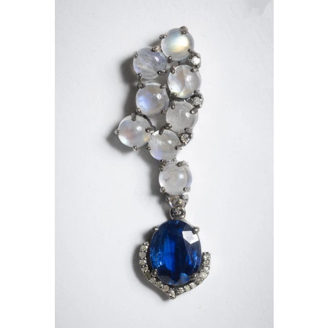 A lovely pair of clustered cabochon rainbow moonstones with a large, faceted oval kyantie gemstones dangling from the...