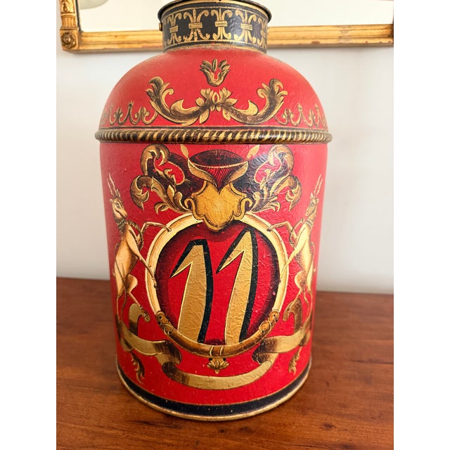 Fun red tole lamp with hand painted black and gold decoration. Includes the black paper shade. Measures 9” wide, 18 1/2"”...