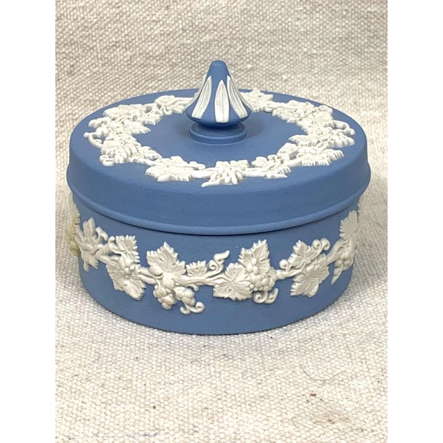 Vintage Wedgwood blue and white jasperware trinket box beautifully decorated with a grape vine design. This is a pre-owned...