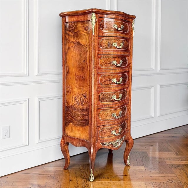 A striking vintage semainier in the Louis XV style, showcasing richly figured walnut burl veneer, serpentine lines, and...