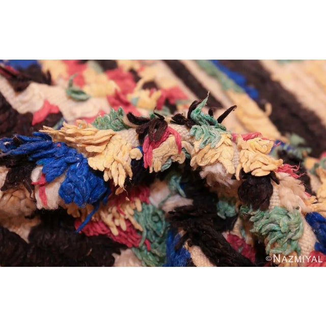 Densely decorated, this charming vintage rug from Morocco features a lovely variety of colorful compartments and segmented...