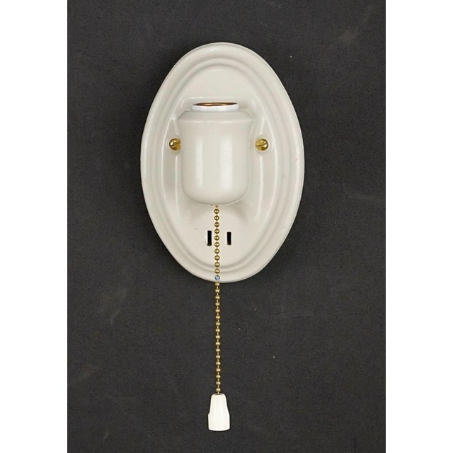 Traditional white porcelain oval wall sconces with pull chains. Each sconce requires one Edison style medium base bulb....
