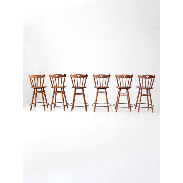 A set of six 1960s Tell City swivel counter stools crafted in the Early American style with sculpted maple seats, turned...