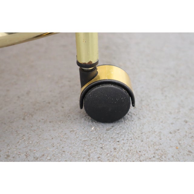 Bar on wheels from the 70s. The panes are made of dark glass. The construction is made of metal painted in gold colour....