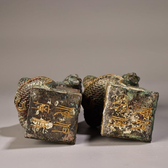 A handsome pair of Chinese bronze figurines depicting mythical water-drawing beasts (吸水兽, "xishui shou"), each crouching...