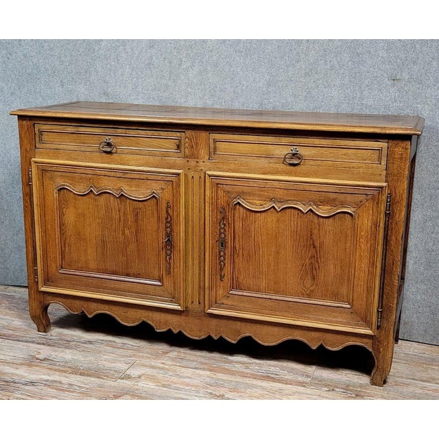 Very large Louis XV period buffet in solid oak, circa 1750. Opening at the front with two molded doors and two drawers,...