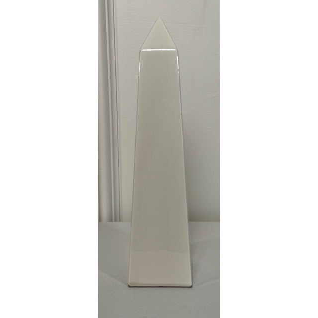 A classical Roman style obelisk consists of creamy white ceramic with a glossy finish. In a moderate size to be places on...