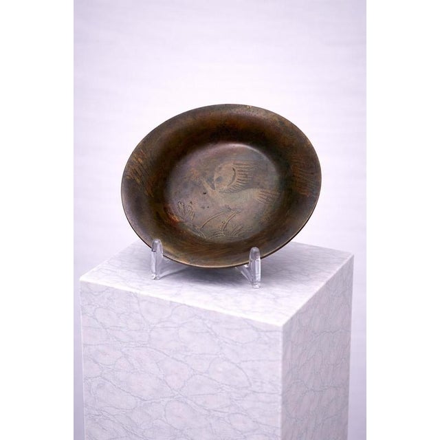 Elegant mid-century Danish bronze bowl by Kromo, featuring a finely engraved heron motif to the interior. The shallow,...