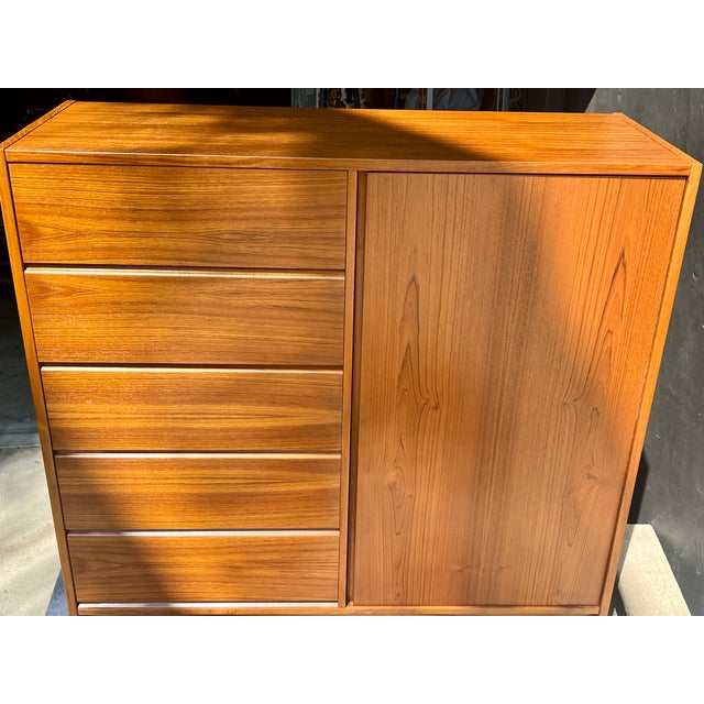 An exceptional, investment-grade mid-century modern find. This 1960s Danish Modern teak armoire dresser (gentleman’s...