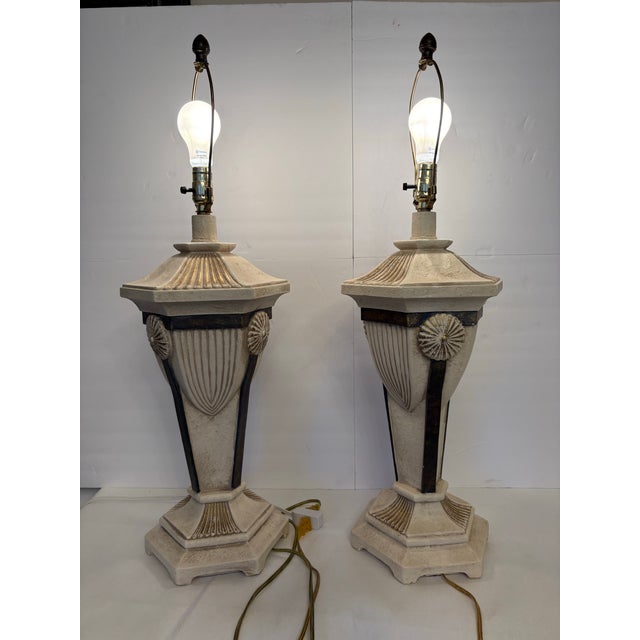 A striking pair of vintage Postmodern table lamps designed with distinct Neoclassical architectural flair. Formed as...