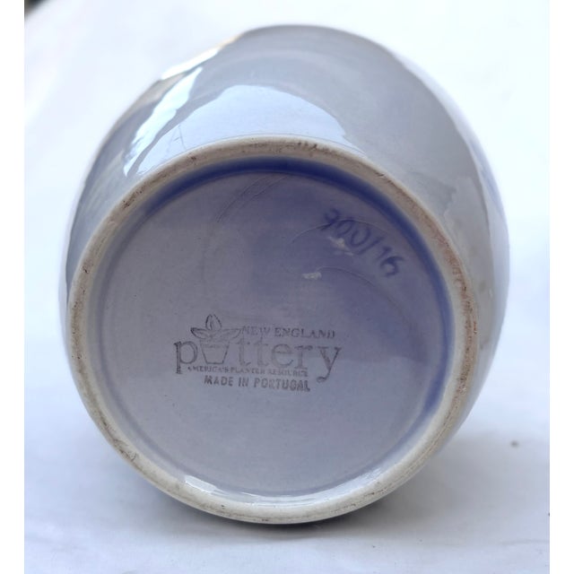 Made in Portugal, this cachepot/planter is light gray with a cobalt blue flower painted on the front. A fine example of...