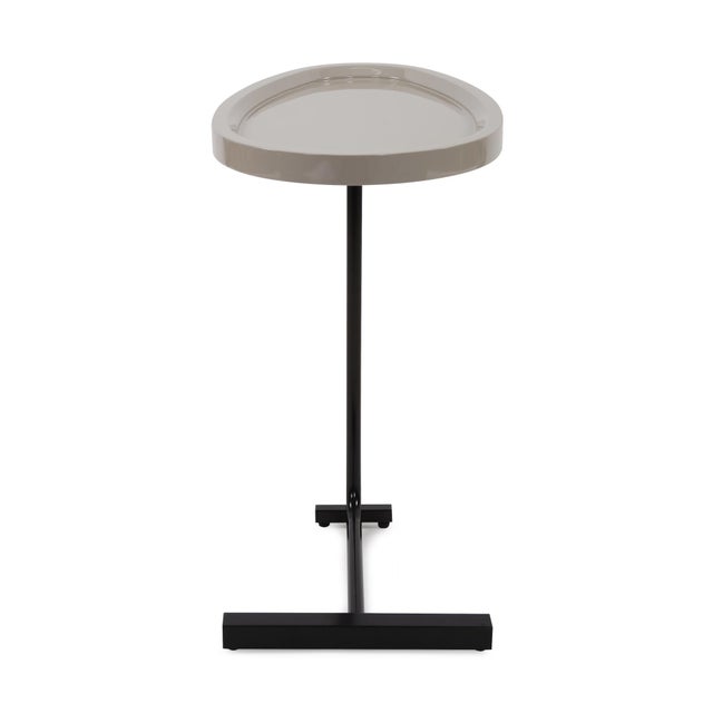 The Tobin drink table features a beautifully balanced glossy black metal base and sleek gray/beige lacquered rounded tear...