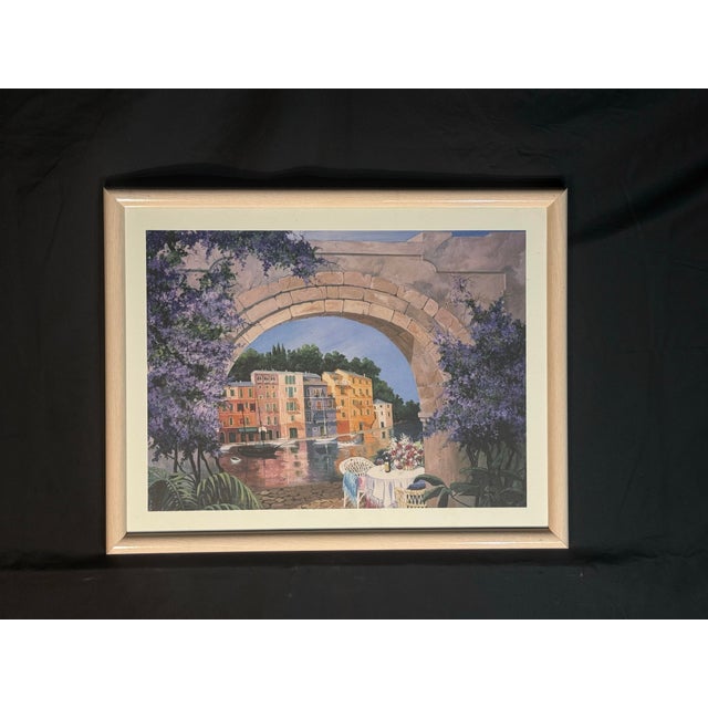 Beautiful framed Mediterranean-style waterfront art print featuring an archway view, colorful buildings, water, flowers,...