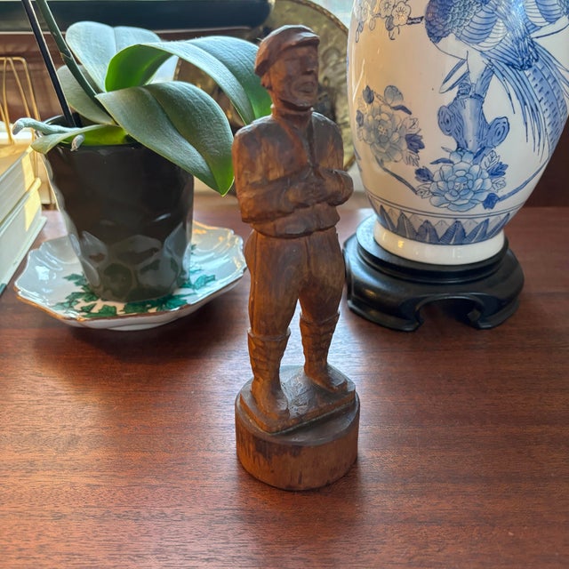 Charming rustic folk art hand-carved figure depicting a weathered gentleman, wearing a turtleneck, boots, and an oyster...
