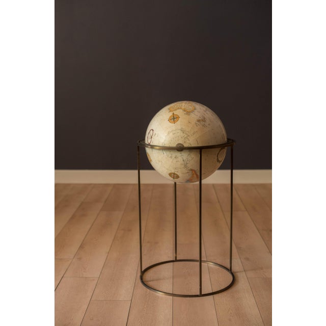 Vintage world map 16" Replogle globe with stand in brass, circa 1970's. This piece rotates on a full swing meridian and...
