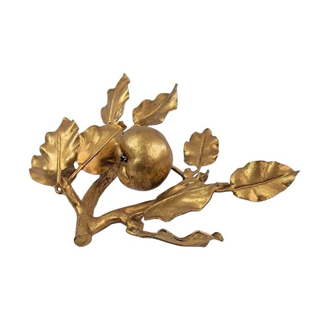 A charming, vintage, gilt tole apple object. Features an apple on a branch surrounded by leafy foliage. Applied gilt...