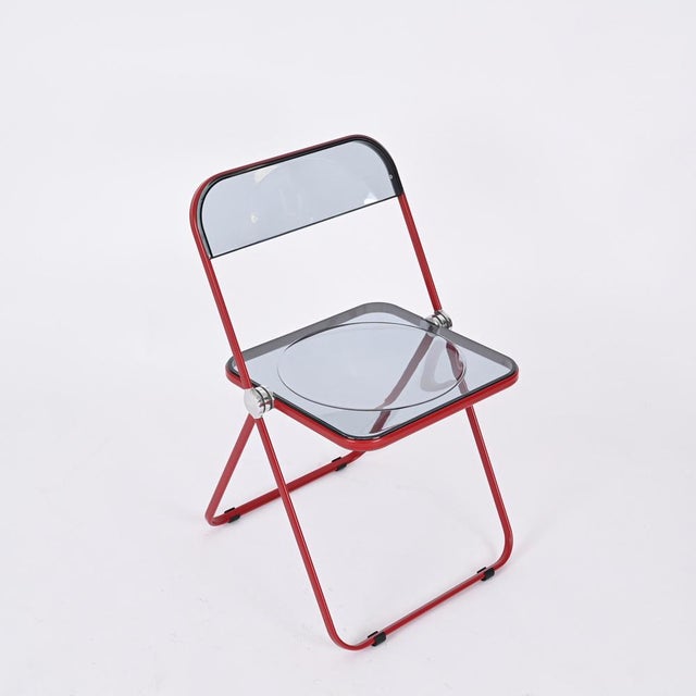Fantastic set of 6 original and signed "Plia" chairs with a vibrant red metal structure and smoked acrylic seat. This...