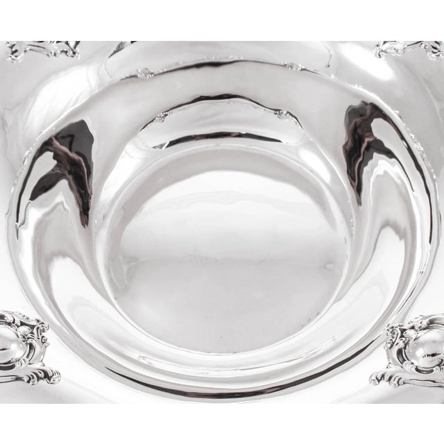 This sterling silver bowl has a scalloped edge with raised-work along the rim. Four medallion-like designs surrounded by...