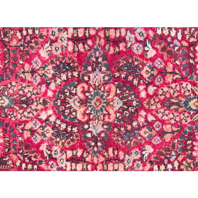 A charming early 20th century Persian Sarouk rug with a central floral medallion living in a field with a mirrored floral...