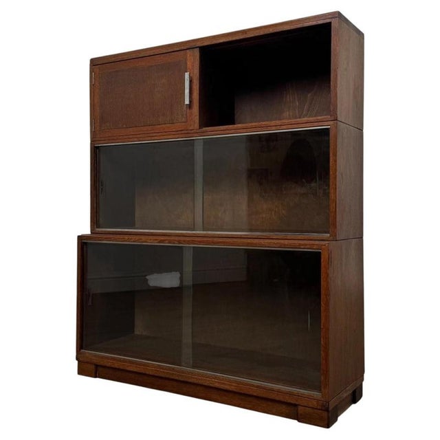 A handsome 20th-century English glazed cabinet by Minty Ltd, finely crafted from oak and distinguished by its unusual...