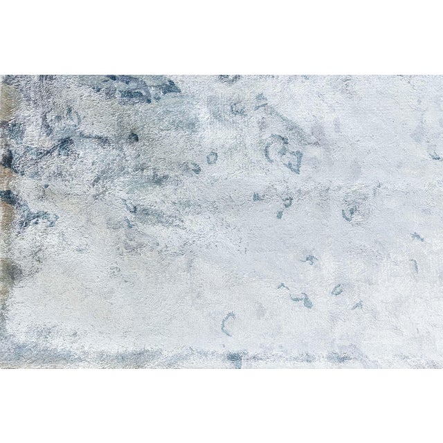 This contemporary hand-tufted silk rug features an elegant water-inspired design, evoking the fluid movement of rippling...