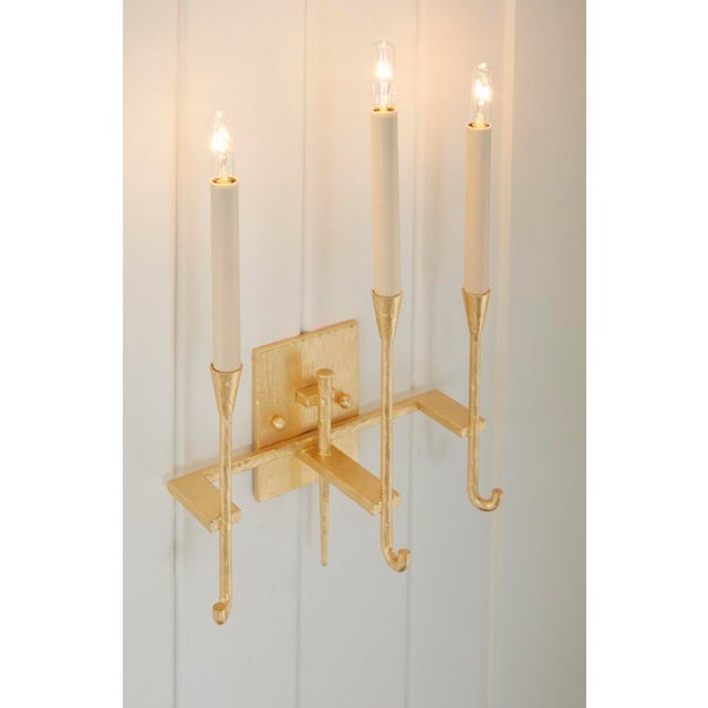 Hammered gold leaf over steel sconce with three electrified candles. 17h x 11.8w x 6d