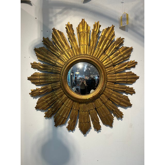 Timeless and glamorous antique giltwood sunburst mirror having 7.5” diameter convex central mirror with wonderfully carved...