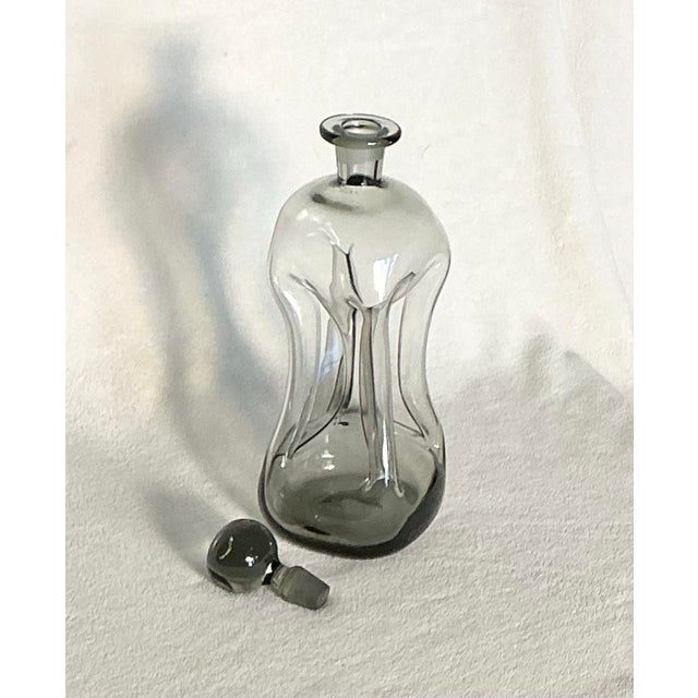 This is a vintage Danish glass works company HOLMEGAARD "Kluk Kluk" decanter in smoke glass, designed by Jacob E. Bang in...