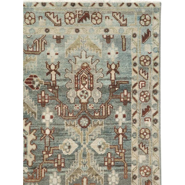 This mid-20th-century Persian Malayer rug presents a distinctive allover geometric-floral pattern across a muted blue-grey...