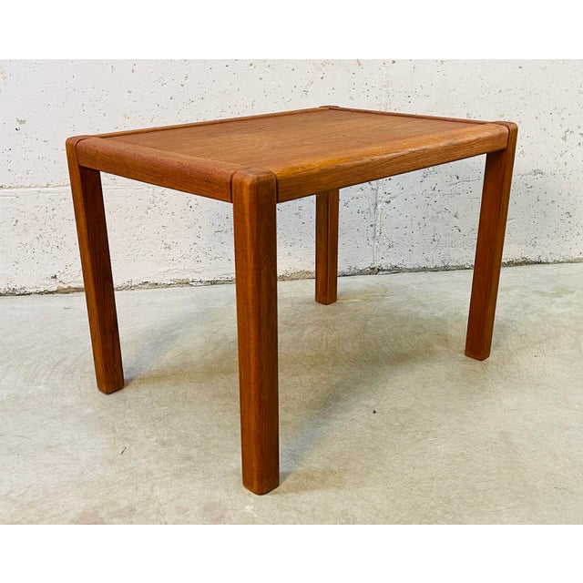 Vintage 1970s rectangular solid teak wood side table. The table has square legs. The table is solid and sturdy. Marked...