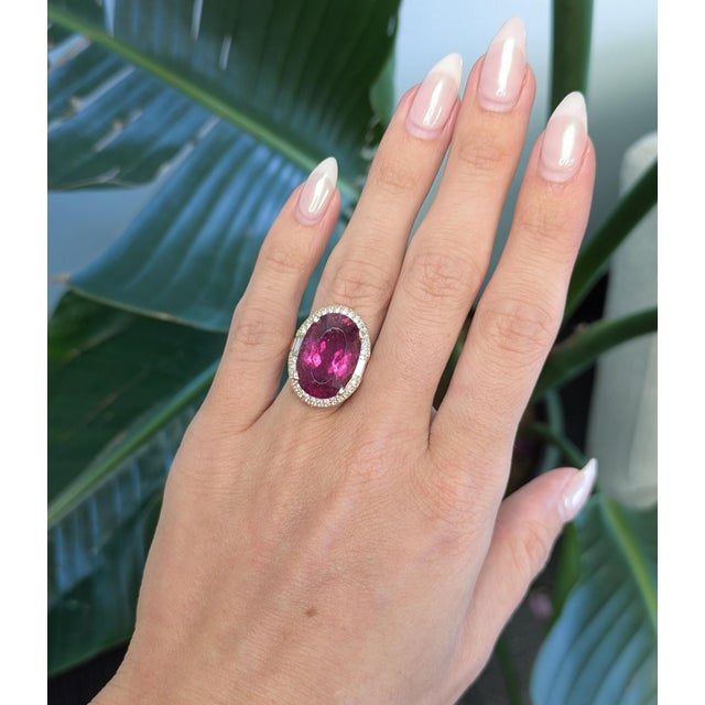 Bold and luxurious, this ring showcases a stunning 15.5ct rubellite tourmaline in an elegant 19 x 13 mm oval cut with...