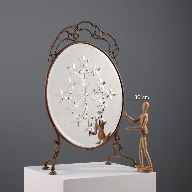 Beveled table mirror with plant motif decorations. This piece is attributed to the mentioned designer/maker. It has no...