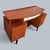 a lebus dressing table or desk with a floating top supported on brass-coloured fittings. Details circa 1950s–60s; teak-...
