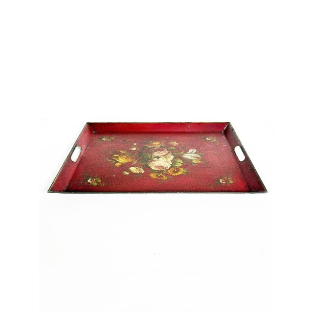 Charming antique painted metal tray dating from the 1940s, featuring a deep red background decorated with an elegant...